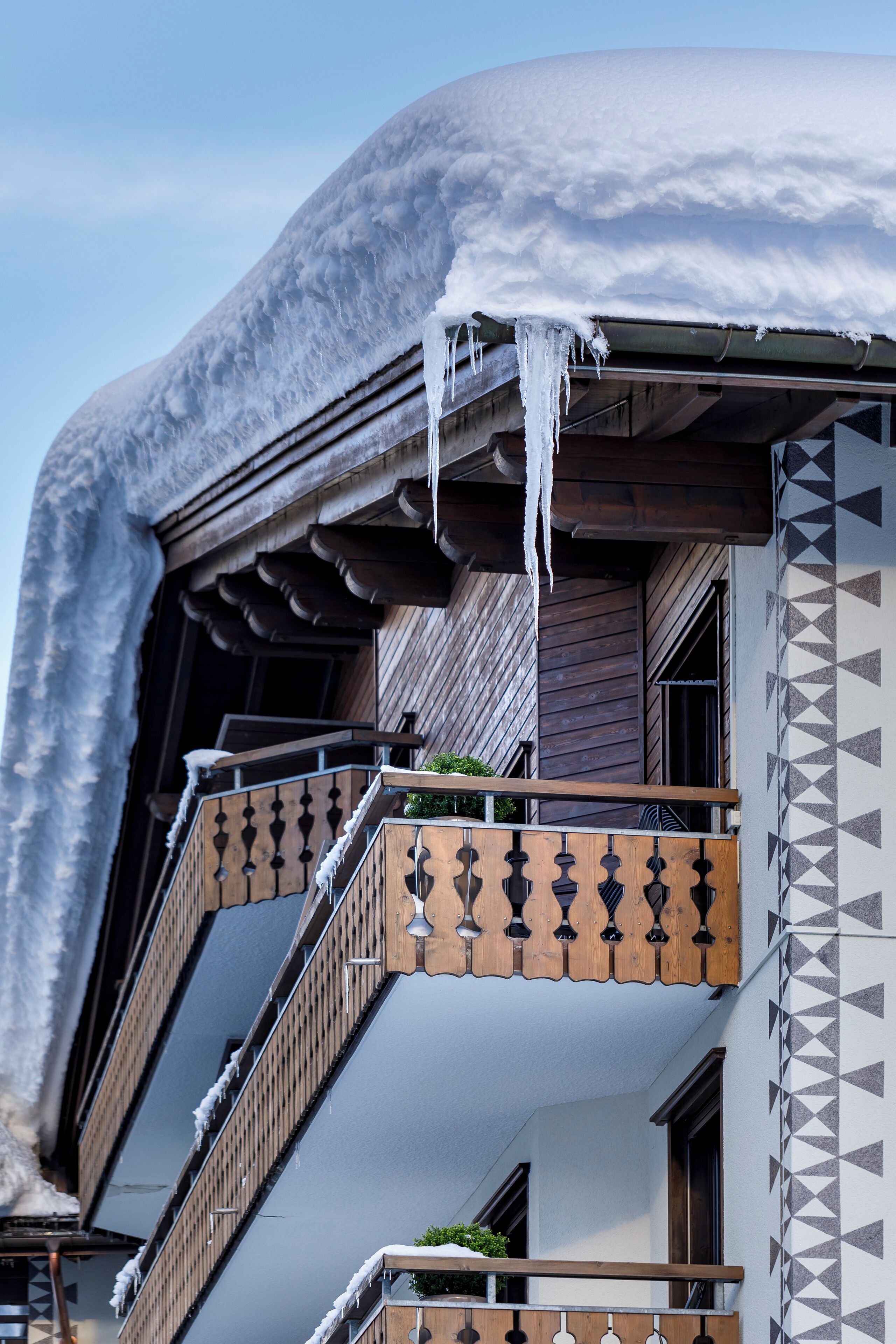 A building with a snow-covered roof and icicles hanging from the eaves.