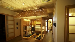 Un intérieur japonais traditionnel avec un sol en tatamis, des portes coulissantes et un plafond en bambou.