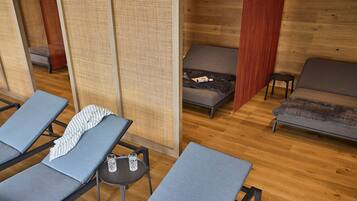 Un spa moderno con suelos de madera, un sofá y varios sillones de descanso.