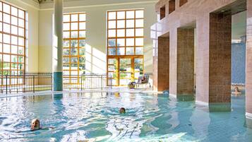 Relax by the rectangular pool surrounded by a tiled deck and large windows.
