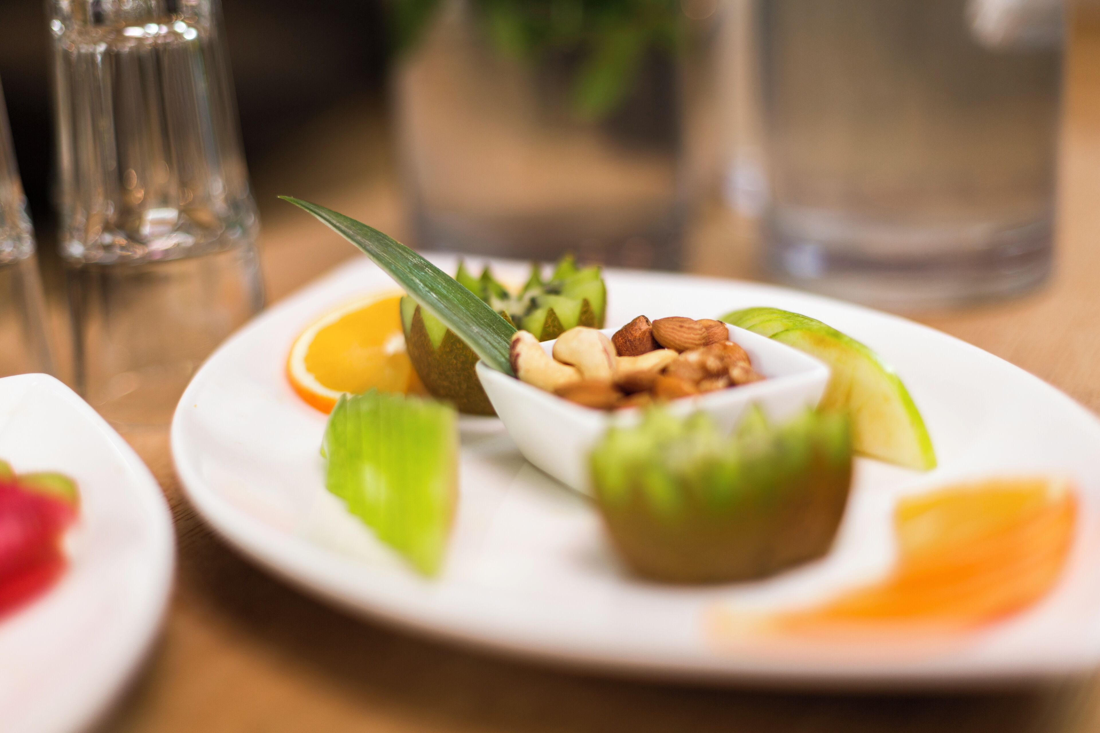 Un plato con un postre de nueces y rodajas de fruta.