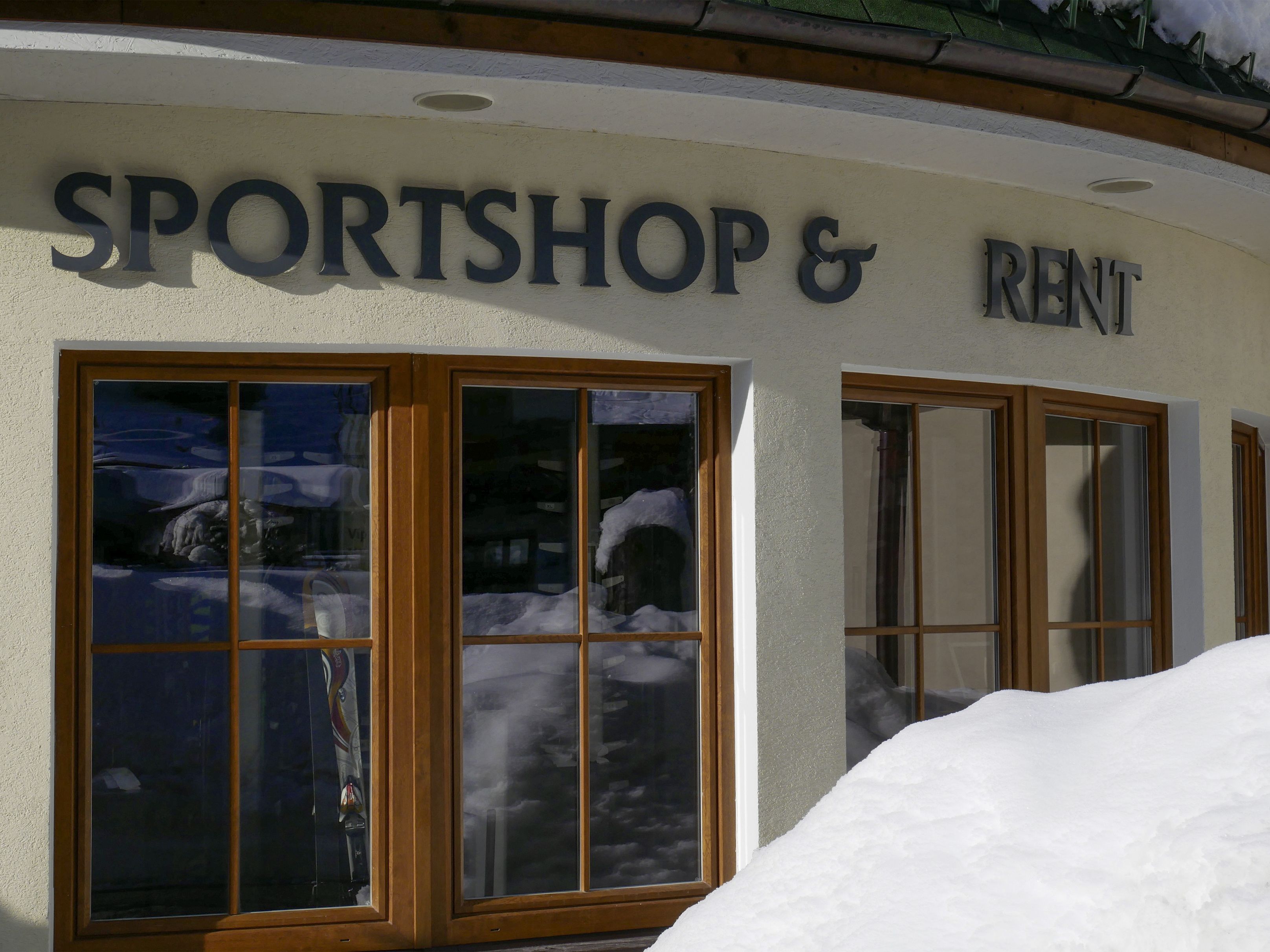 Un bâtiment sur lequel on peut lire l’inscription suivante : « MAGASIN D’ARTICLES DE SPORT ET LOCATION ».