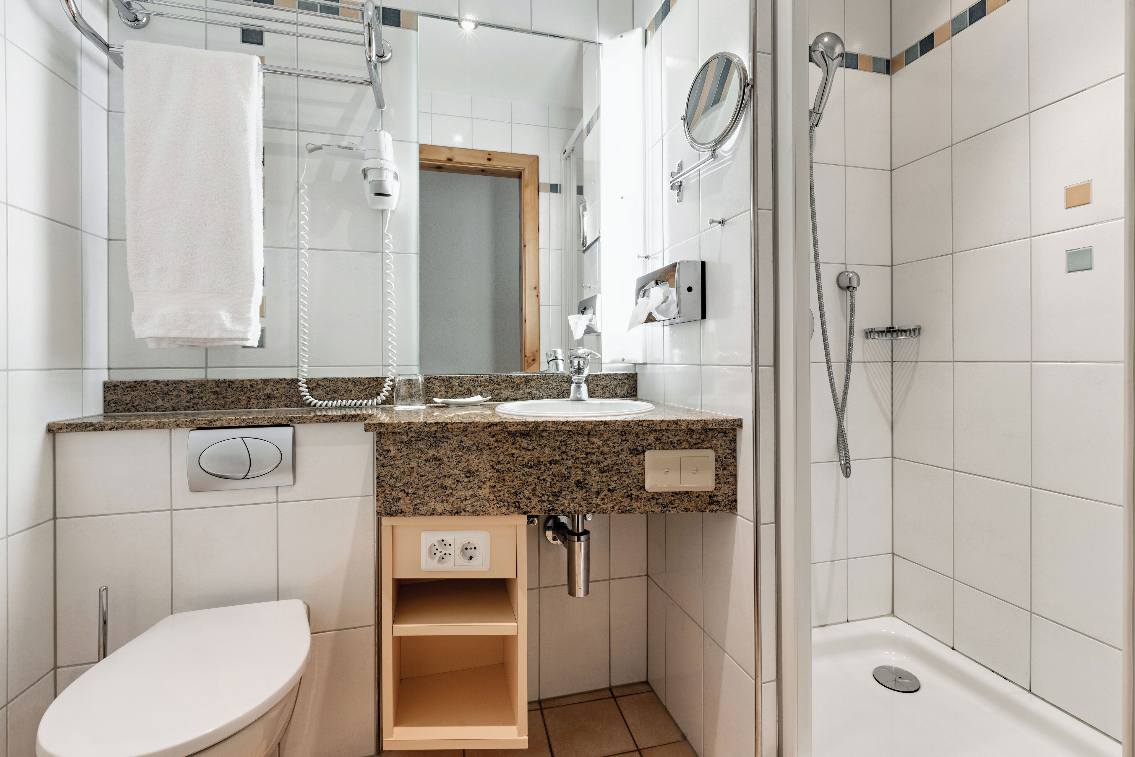 Un bagno compatto con il water, lavandino e doccia.