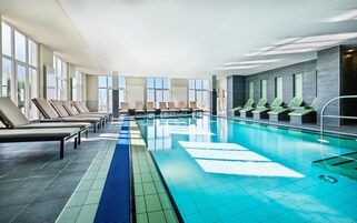 Una piscina con sillones de descanso y vistas al exterior.