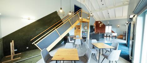 A modern interior with a staircase, seating area, and a play area.