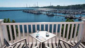 Ein Balkon mit Tisch und Stühlen mit Blick auf einen Yachthafen und Boote.