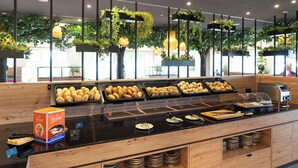 A buffet area with various baked goods and a coffee station.
