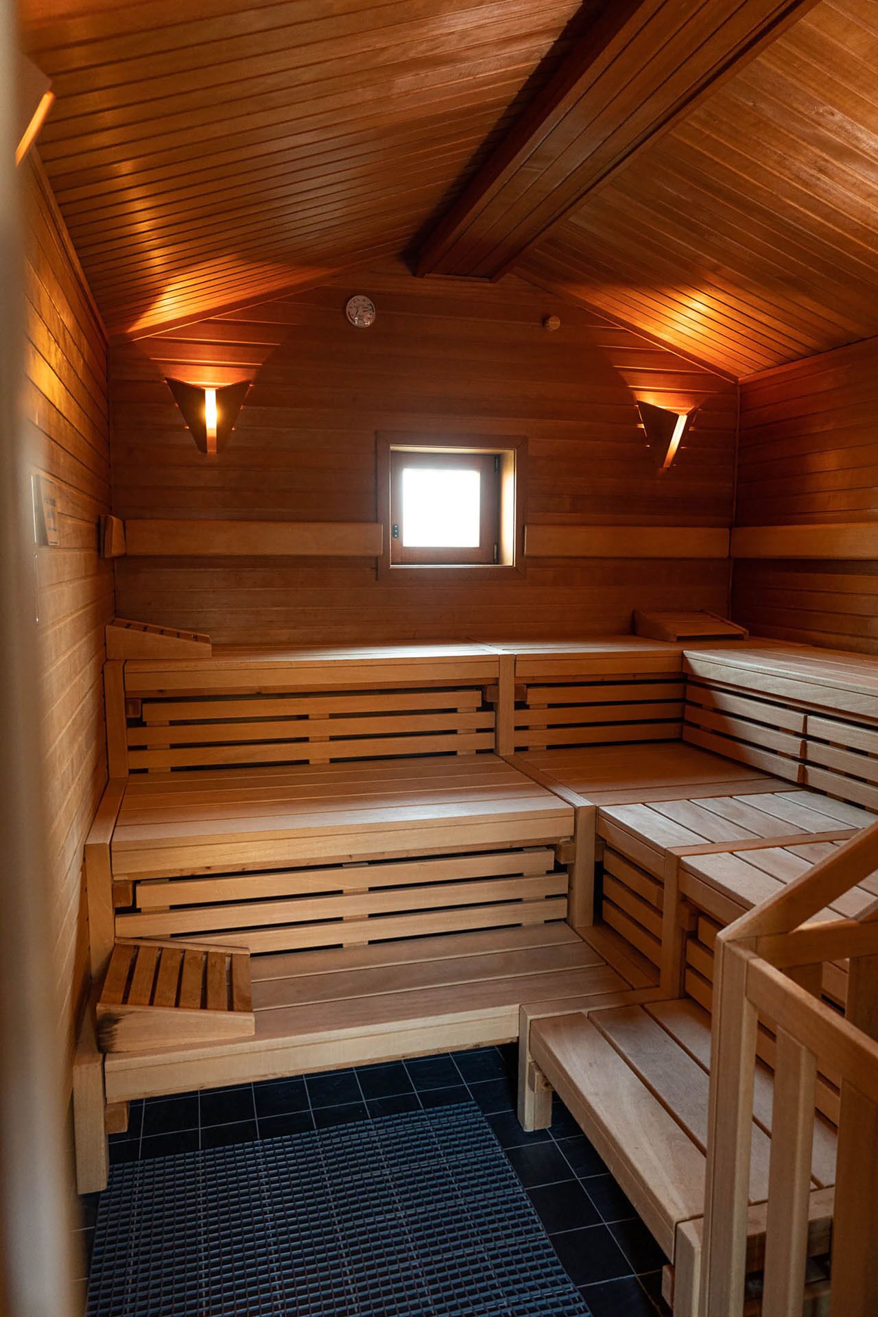 Eine Sauna mit Holzbänken und einem kleinen Fenster.
