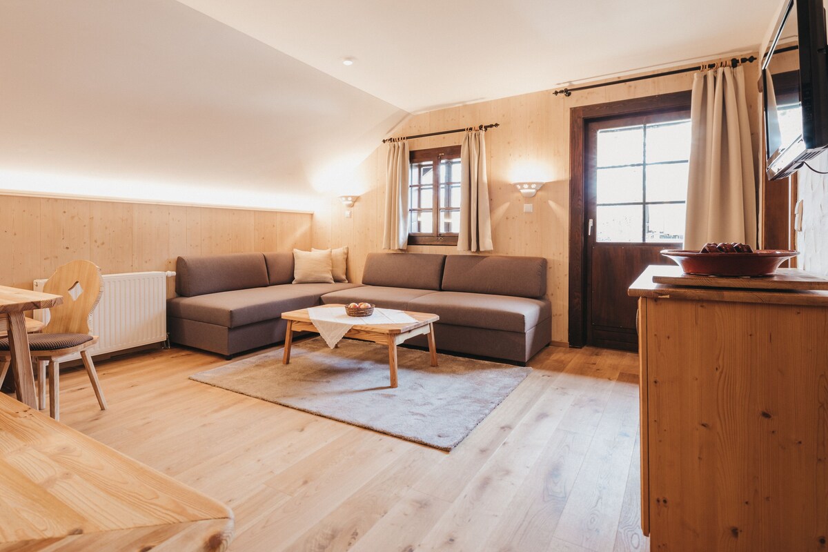 A cozy living room with a sofa, a coffee table, and a dining area with a table and chairs.