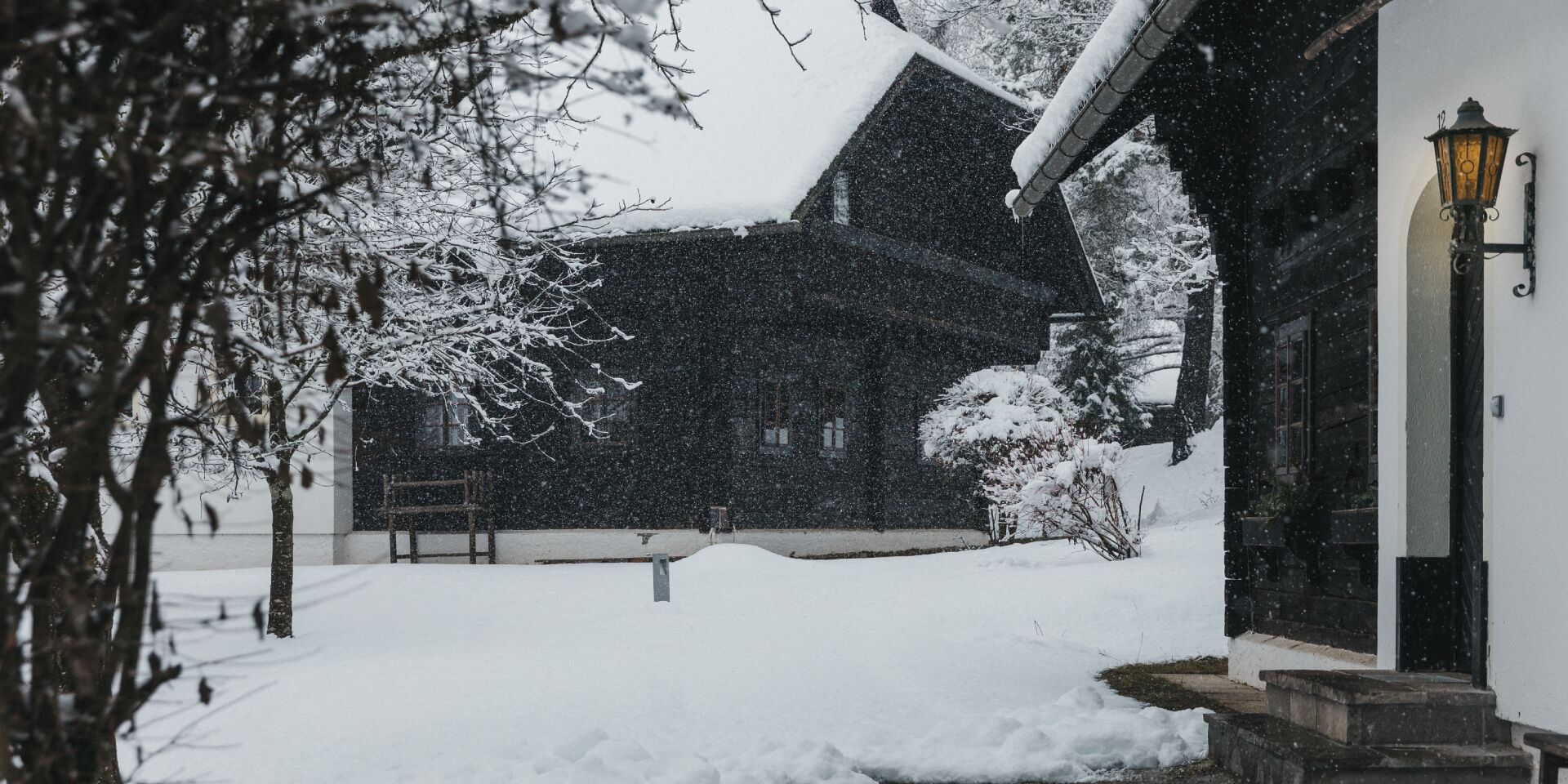 Un bâtiment recouvert de neige, avec une entrée bien visible et un lampadaire.