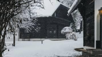 Un bâtiment recouvert de neige, avec une entrée bien visible et un lampadaire.