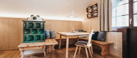 A wooden interior with a wooden bench, a table, and a green cabinet.