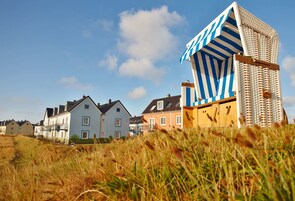 Une rangée de maisons avec un cabanon de plage au premier plan.