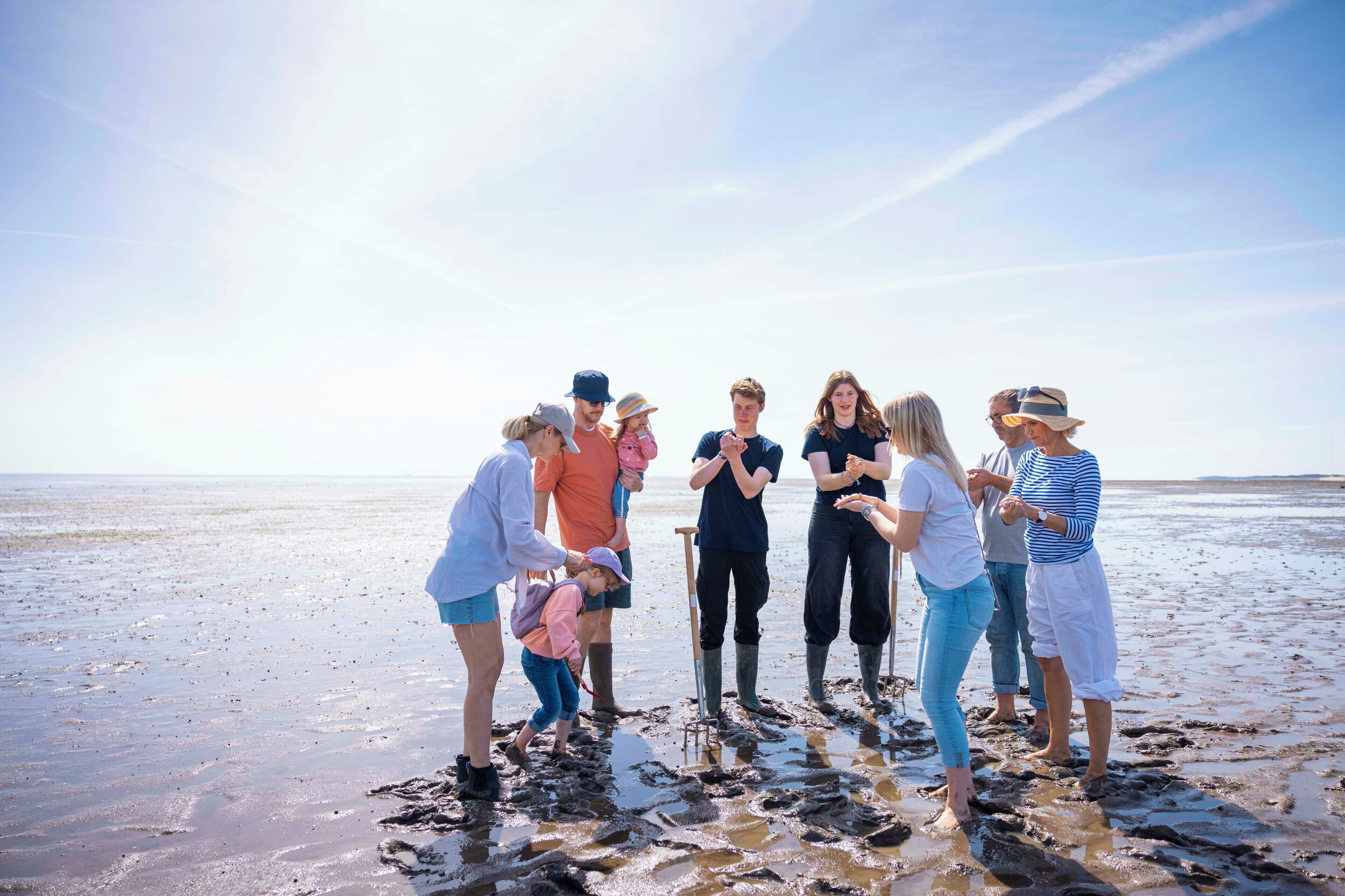 A group of people on a beach with a clear sky.