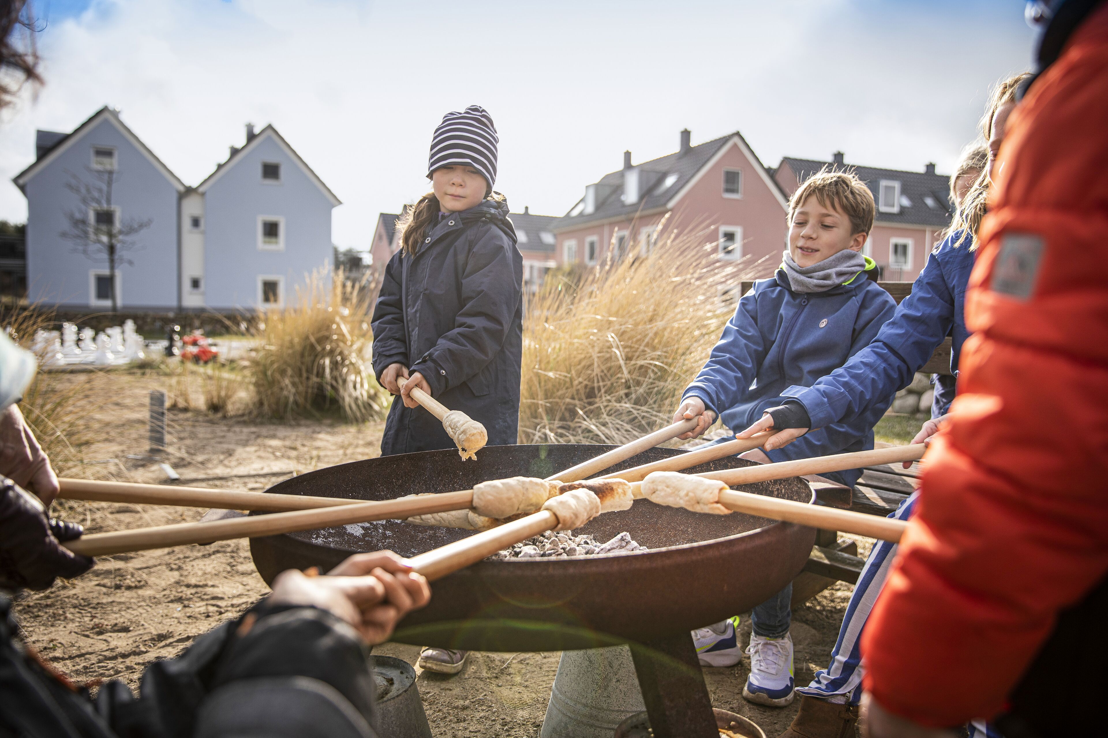 Een groep mensen gebruikt een grote buitenkookpot.