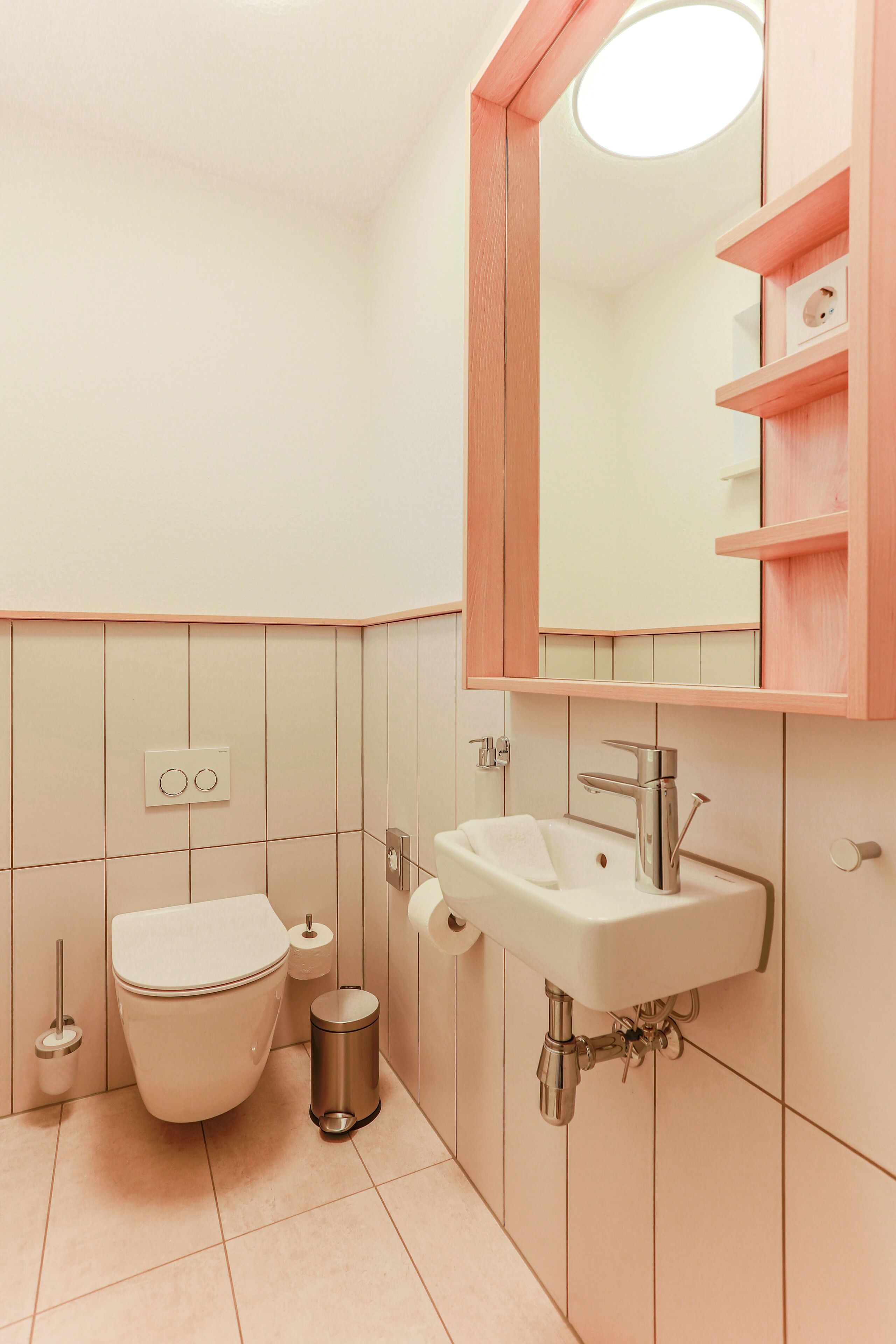 Ein Badezimmer mit Toilette, Waschbecken und Spiegel.