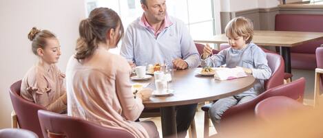 A family dining at a round table with chairs around it.