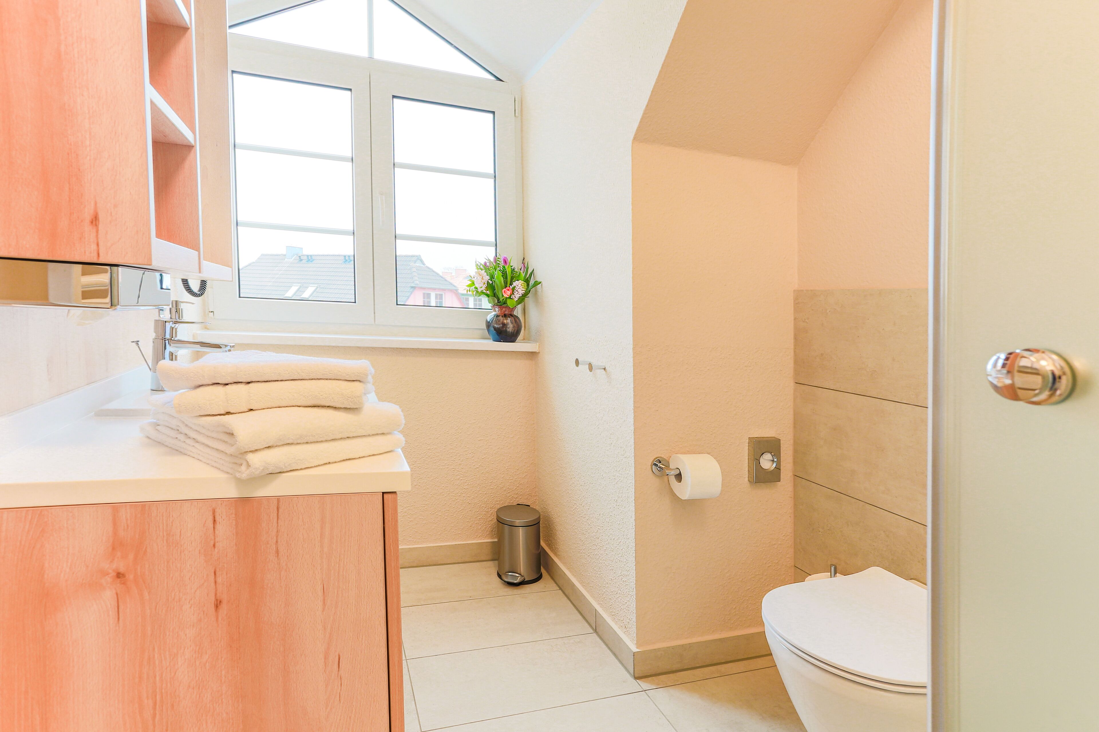Een moderne badkamer met toilet, wastafel en raam.