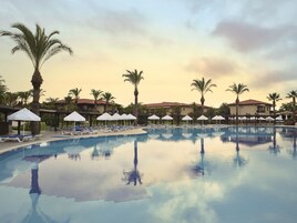 Una piscina al aire libre, sombrillas, tumbonas