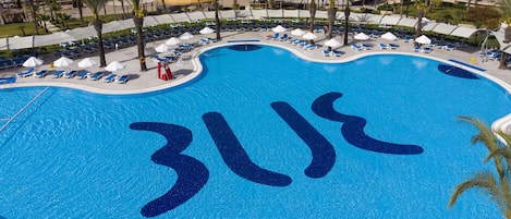 Een buitenzwembad, parasols voor strand/zwembad