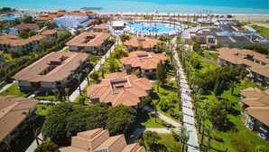 A resort with multiple buildings, a central pool area, and a beach in the background. - TUI BLUE Palm Garden - All inclusive (Manavgat)