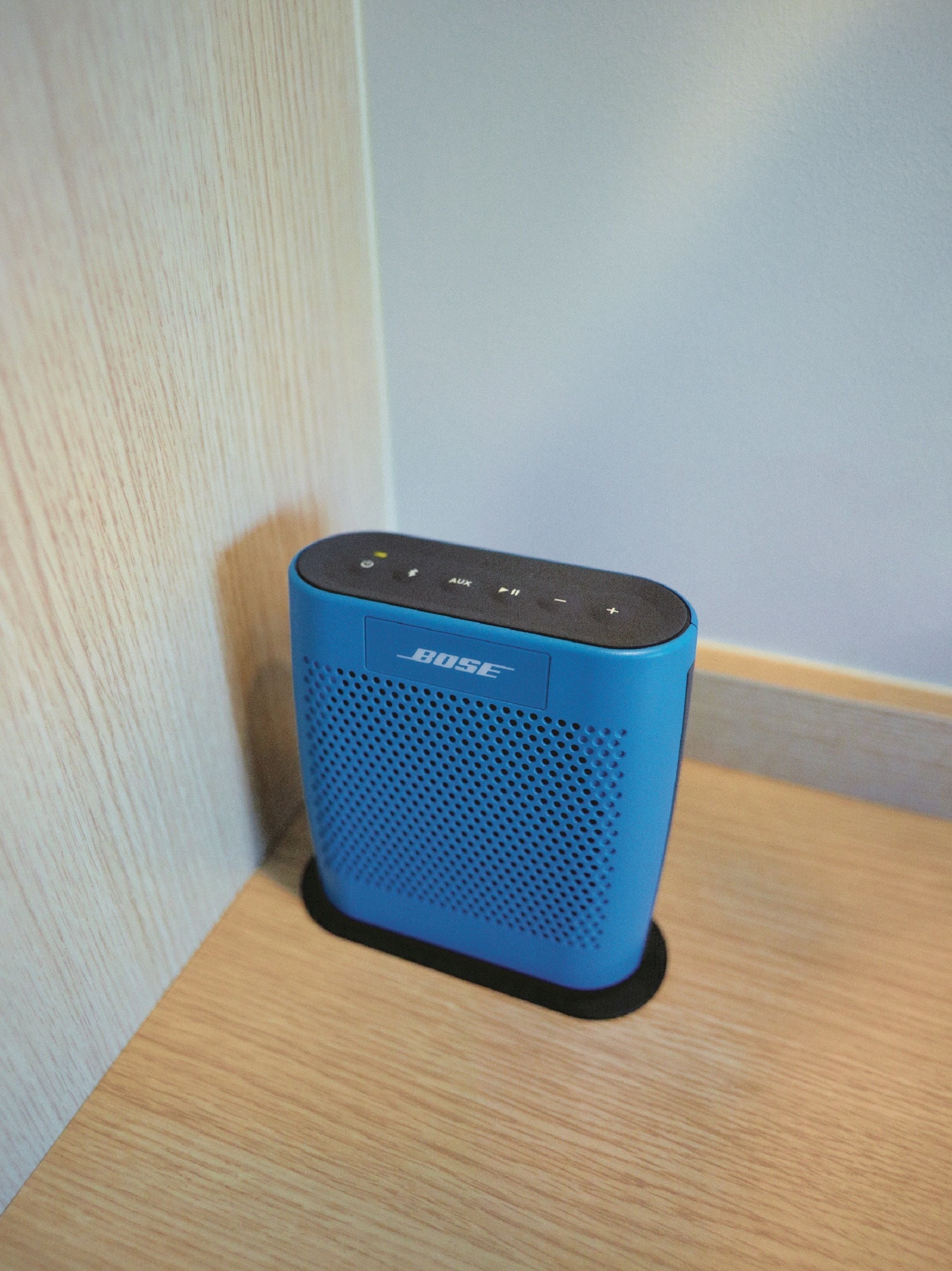 Un altaveu blau de Bose sobre una superfície de fusta.