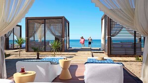 A beachside lounge with cushioned seating, a wooden deck, and a view of the sea. - TUI BLUE Palm Garden - All inclusive (Manavgat)