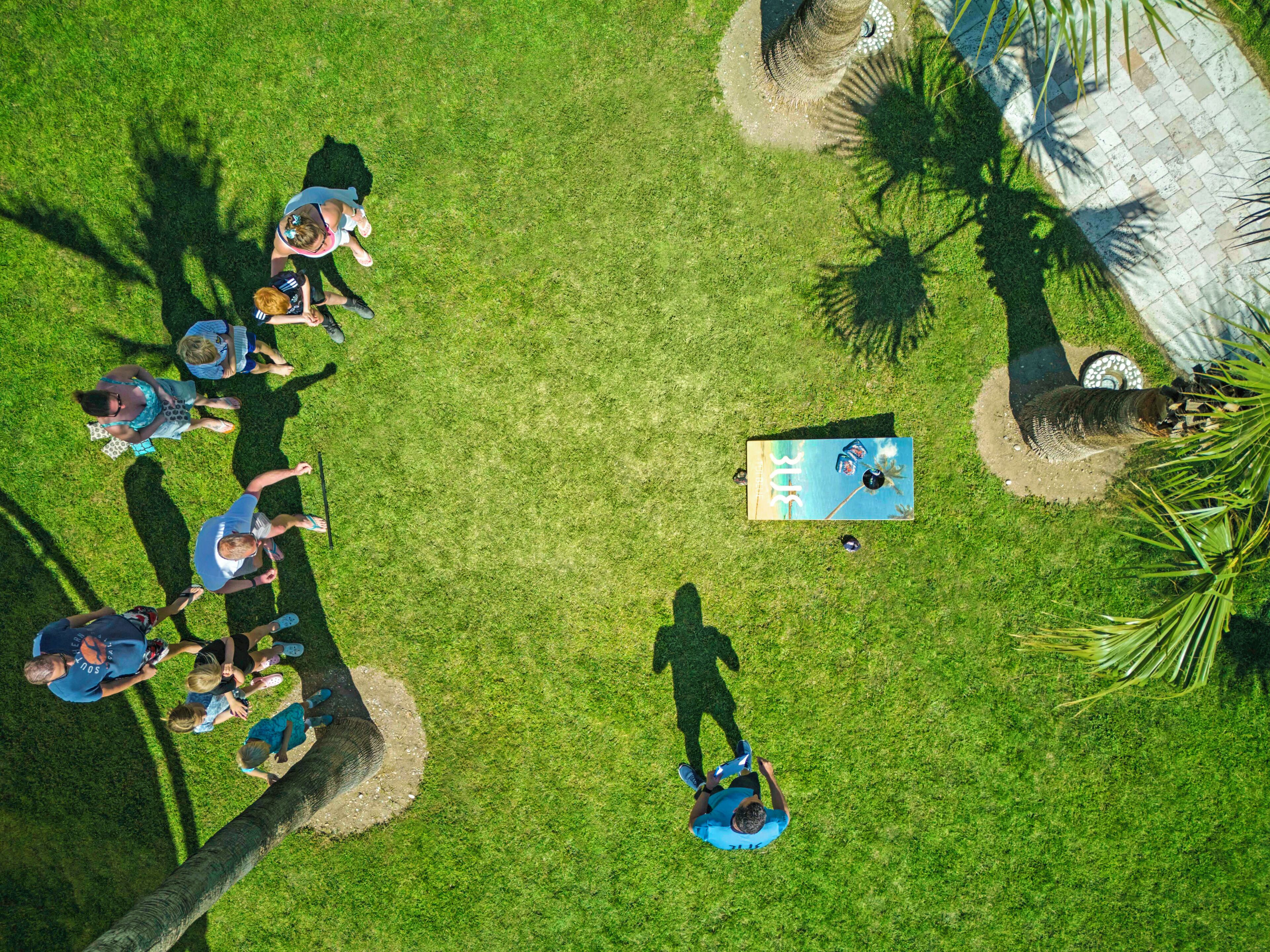 Vista aérea de un área verde con un grupo de personas reunidas alrededor de una mesa, posiblemente para un evento o reunión.