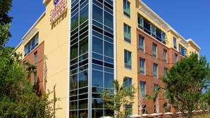 A hotel with a yellow facade, large glass windows, and a sign reading "Comfort Suites." - Comfort Suites Charleston West Ashley (Charleston)
