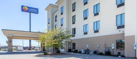 A Comfort Suites hotel with a parking lot, a covered entrance, and a building facade with multiple windows.
