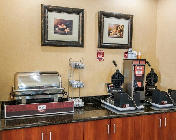 Un bar à petit-déjeuner équipé d’appareils à gaufres, d’une machine à café et d’une plaque de cuisson.