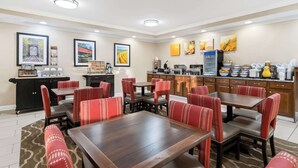 A hotel dining area with red upholstered booths, a buffet setup, and framed artwork on the walls. - Comfort Inn Hebron-Lowell Area (Hebron)