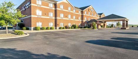 A Comfort Inn hotel with a brick facade, multiple windows, and a covered parking area.