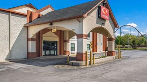 Een hotelingang met een boog, een bord met EconoLodge en een parkeerplaats.