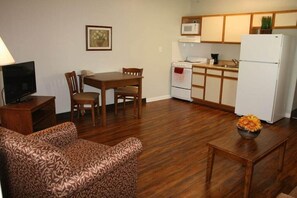 Un espacio habitable compacto con comedor, kitchenette y zona de estar.