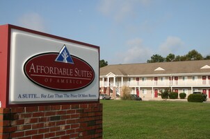 Letrero de Affordable Suites of America, un motel con fachada de ladrillo y un letrero grande.