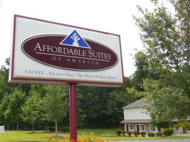 Un cartel de Affordable Suites of America, destacando su excelente relación calidad-precio.