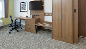 A modern office space with a desk, chair, television, and wardrobe. - Holiday Inn Express & Suites San Antonio NW near SeaWorld by IHG (San Antonio)