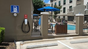 An electric vehicle charging station, a pool area, and a gated entrance to a residential building. - Holiday Inn Express & Suites San Antonio NW near SeaWorld by IHG (San Antonio)