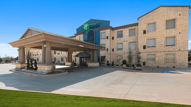 A Holiday Inn Express hotel with a covered entrance, a brick facade, and a clear blue sky. - Holiday Inn Express & Suites Oklahoma City NW-Quail Springs by IHG (Oklahoma City)