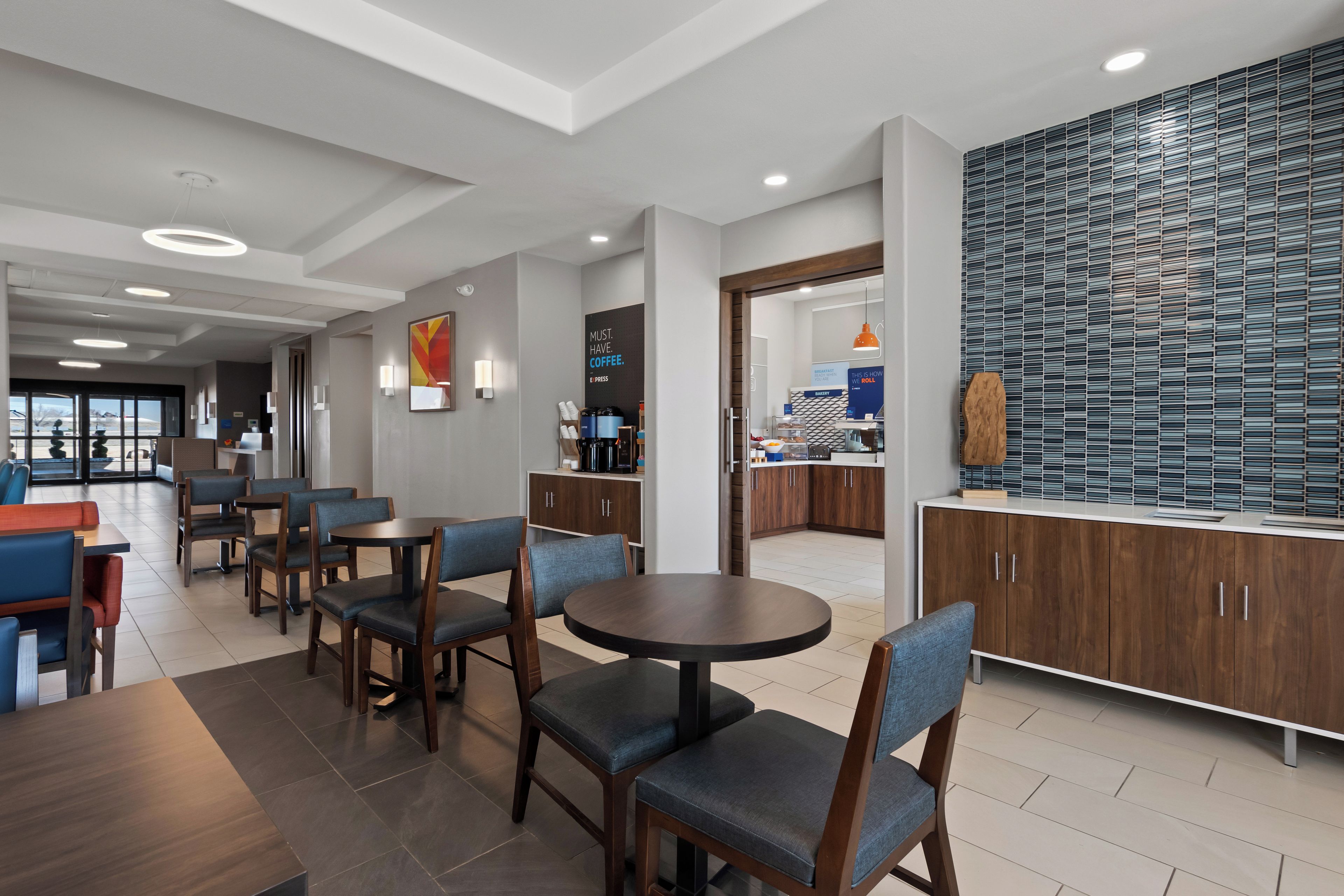 Una moderna hall dell'hotel con area ristorazione, panetteria e cucina.