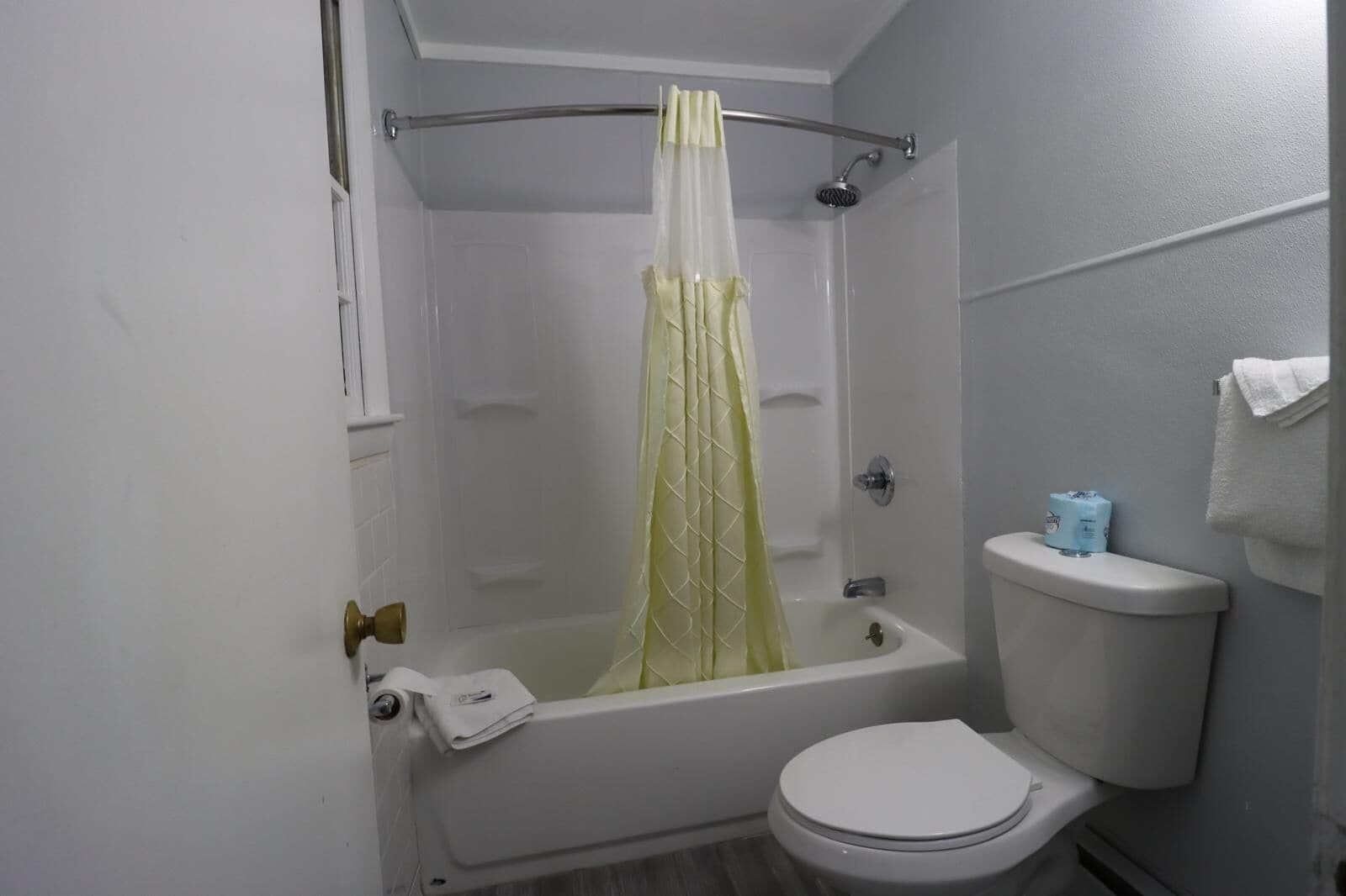Une salle de bain avec une baignoire, des toilettes et un rideau de douche.