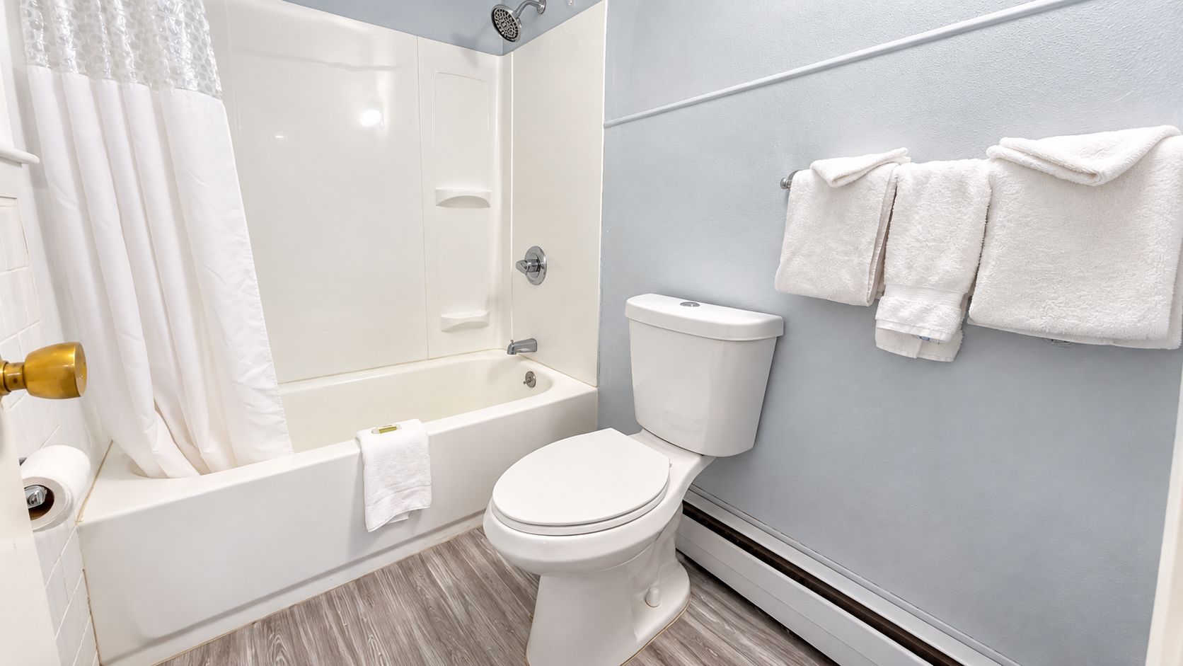Ein Badezimmer mit Badewanne, Toilette und Handtuchhalter.