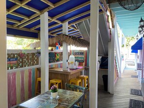 An outdoor seating area with a table, chairs, and a sign about ocean lessons. - Caribbean House (Key West)