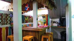 Ein farbenfrohes Interieur mit Bar, Hockern und einer Flagge.
