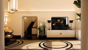 A lobby with a reception desk, a staircase, and a decorative floor pattern. - Palazzo Ripetta (Rome)