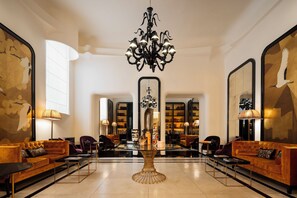 A spacious lobby with a central chandelier, seating areas, and a large mirror reflecting the space. - Palazzo Ripetta (Rome)