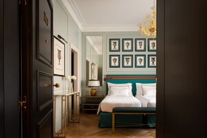 Un dormitorio con una cama grande, una mesita de noche, un espejo y cuadros en la pared.