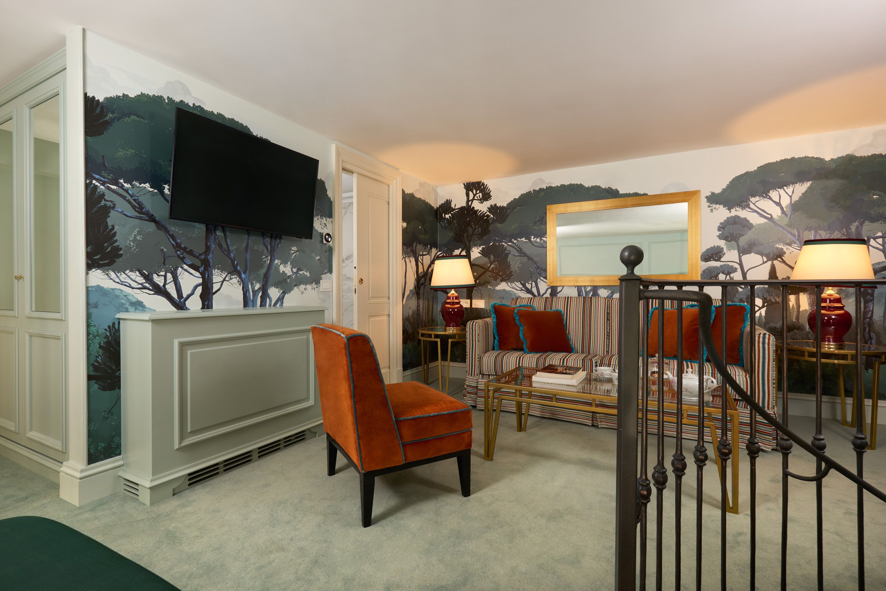 A living room with a fireplace, a television mounted on the wall, a sofa, and a chair.