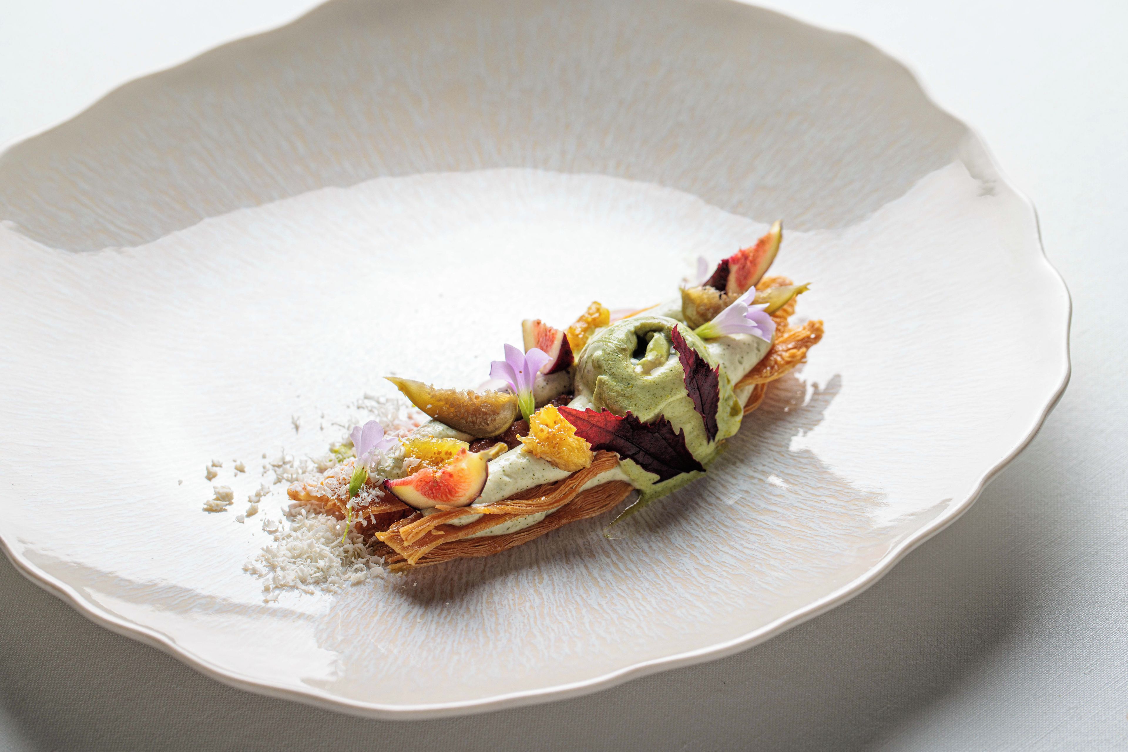 Un plato blanco con un postre en capas.